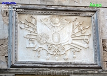 Герб, вырезанный в камне на часовой башне Хан Аль-Умдан