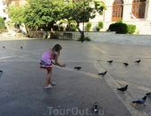 На площади Св. Екатерины очень много голубей. Их подкармливают и отдыхающие и сами греки. Ну а девочка их ловит.