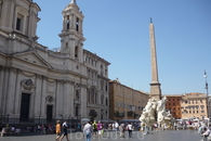 Рим. Piazza  Navona.  Слева,рядом  с  церковью,дворец  Памфили.На обелиске в центре вершина украшена бронзовой голубкой с оливковой ветвью в клюве,фигурирующей ...