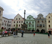 Центральная площадь Крумлова с традиционным "чумным" столбом в центре. 
На самой вершине столба расположена скульптура Девы Марии, у основания – Св. Роха ...