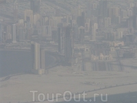 Вид из самолета: город в дымке из-за постоянной строительной пыли.