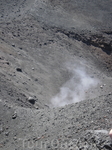 Из открытого в земле "живого" кратера поднимается пар.