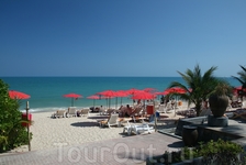 Пляж отеля Викендер. Приятное сочетание голубого моря и пляжных зонтиков алого цвета .