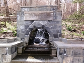 Камень-посмящение на аллее источников в парке