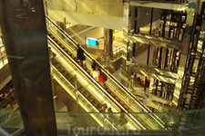 многочисленные лифты и эскалаторы поднимают пассажиров в главный зал из зоны прилёта