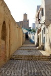 узкие улицы медины, вдалеке видна 30-ти метровая Башня Халифа в Касбе (построена в 859 году)