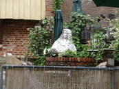 Скульптура перед входом в кафе на воде,ступеньки слева. Кафе расположено под единственным домом с деревянным фасадом, фото дома есть выше.