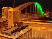 Арочный мост «Каарсильд». 
До него, больее чем полтора столетия, соединял берега реки Эмайыги знаменитый Каменный мост (макет впереди). А в 1959 г. построен арочный мост для пешеходов, железобетонные