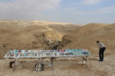 Иудейская пустыня. На смотровой площадке местные жители предлагают купить туристам сувениры. Столик с сувентирами стоит на самом краю обрыва.