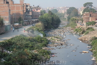 Священная река Багмати протекает через город вся завалена горами мусора