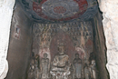 Грот десяти тысяч будд (Ванфо Дун), относящийся к эпохе Тан. Стены пещеры изнутри украшает рельеф из огромного числа миниатюрных будд, по центру в позе ...