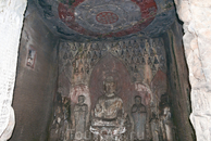 Грот десяти тысяч будд (Ванфо Дун), относящийся к эпохе Тан. Стены пещеры изнутри украшает рельеф из огромного числа миниатюрных будд, по центру в позе ...