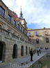 На Plaza del Ayuntamiento напротив собора стоит мэрия Толедо. На флагштоках развеваются 4 флага - Евросоюза, Испании, провинции Кастилья - Ла Манча и флаг ...